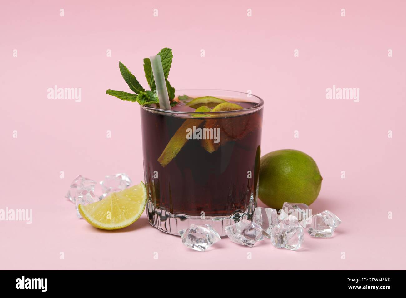 Ein Glas Cuba Libre Cocktail auf rosa Hintergrund Stockfoto