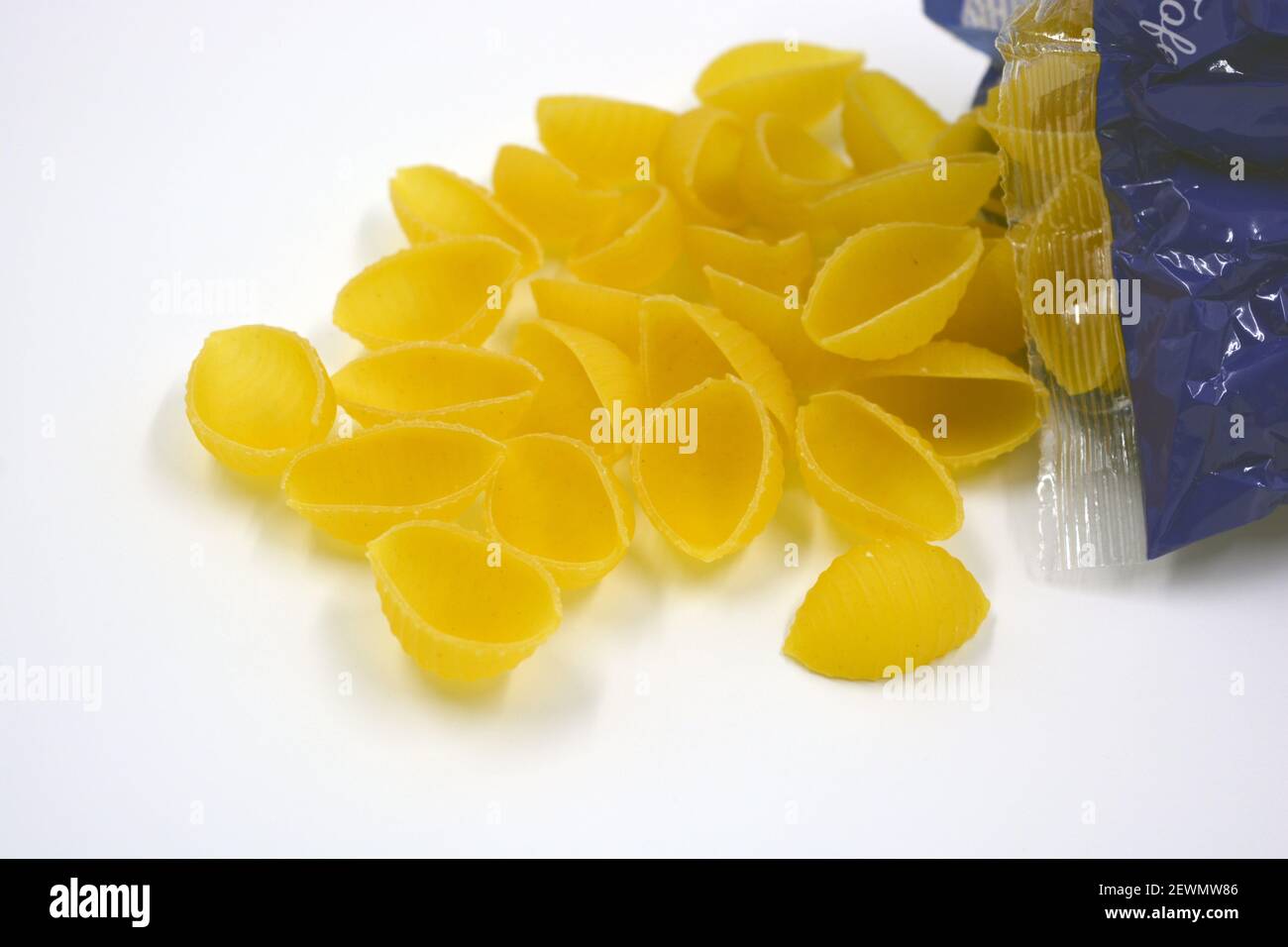 Trockene gelbe italienische Vermicelli, Pasta von Wwkushi Muschelschalen aus Vollkornsorten, befinden sich auf weißem Hintergrund. Stockfoto