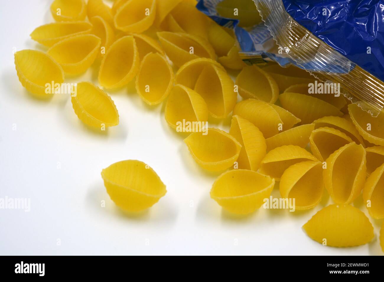 Trockene gelbe italienische Vermicelli, Pasta von Wwkushi Muschelschalen aus Vollkornsorten, befinden sich auf weißem Hintergrund. Stockfoto