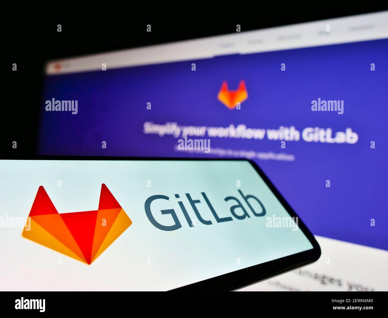Smartphone mit Business-Logo der amerikanischen DevOps-Plattform GitLab Inc. Auf dem Bildschirm vor der Unternehmens-Website. Konzentrieren Sie sich auf die Mitte links des Telefondisplays. Stockfoto