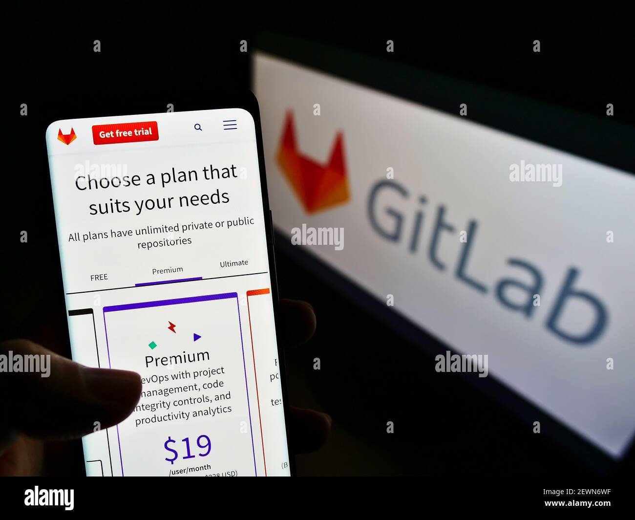 Person, die Mobiltelefon mit der Webseite der US DevOps-Softwareplattform GitLab Inc. Auf dem Bildschirm vor dem Logo hält. Konzentrieren Sie sich auf die Mitte des Telefondisplays. Stockfoto