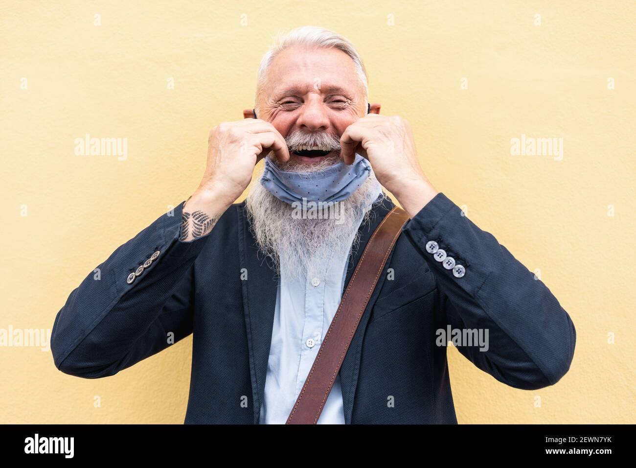 Porträt von glücklichen Hipster Senior Mann mit Maske unter dem Kinn - Fokus auf Gesicht Stockfoto