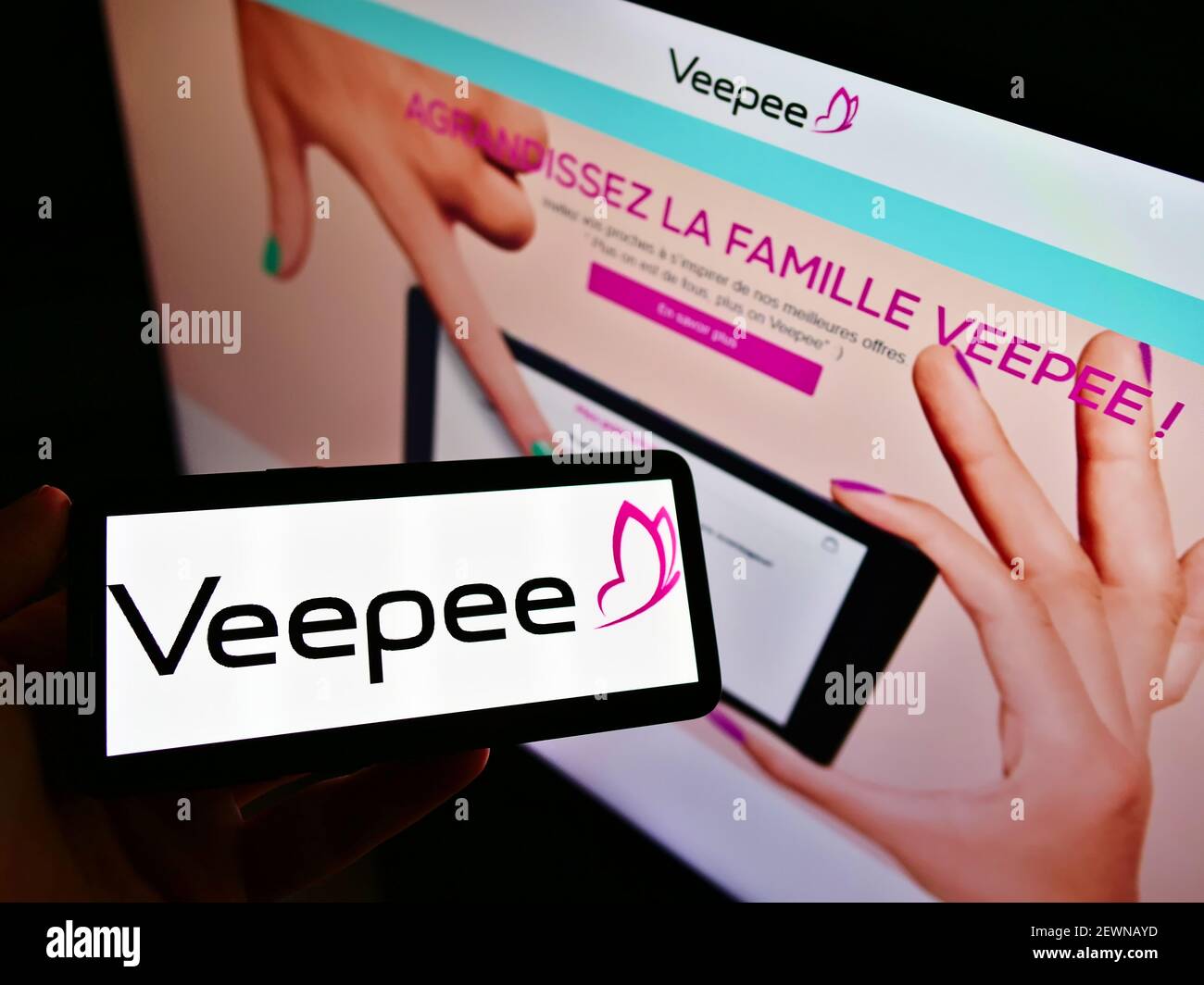 Person mit Mobiltelefon mit Logo des französischen  Einzelhandelsunternehmens Vente-privee.com SA (Veepee) auf dem Bildschirm  vor der Webseite. Konzentrieren Sie sich auf die Telefonanzeige  Stockfotografie - Alamy