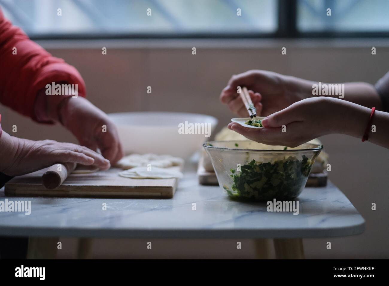 Nahaufnahme von Leuten, die Knödel machen. Traditionelle chinesische Küche während des chinesischen Neujahrs. Chinesisches Kulturkonzept Stockfoto
