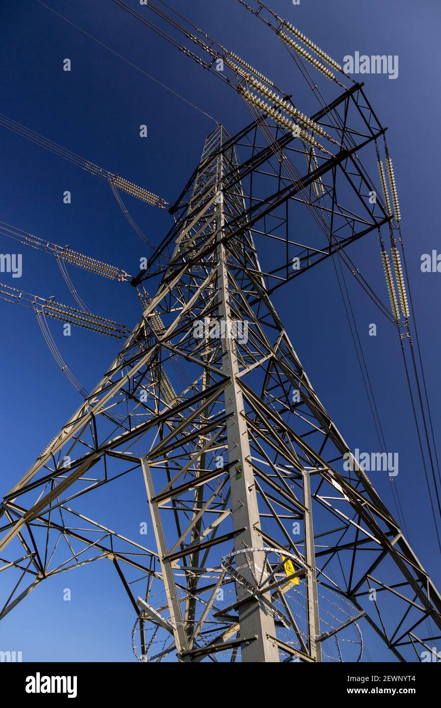 Strommast und Kabel gegen einen blauen Himmel Stockfoto
