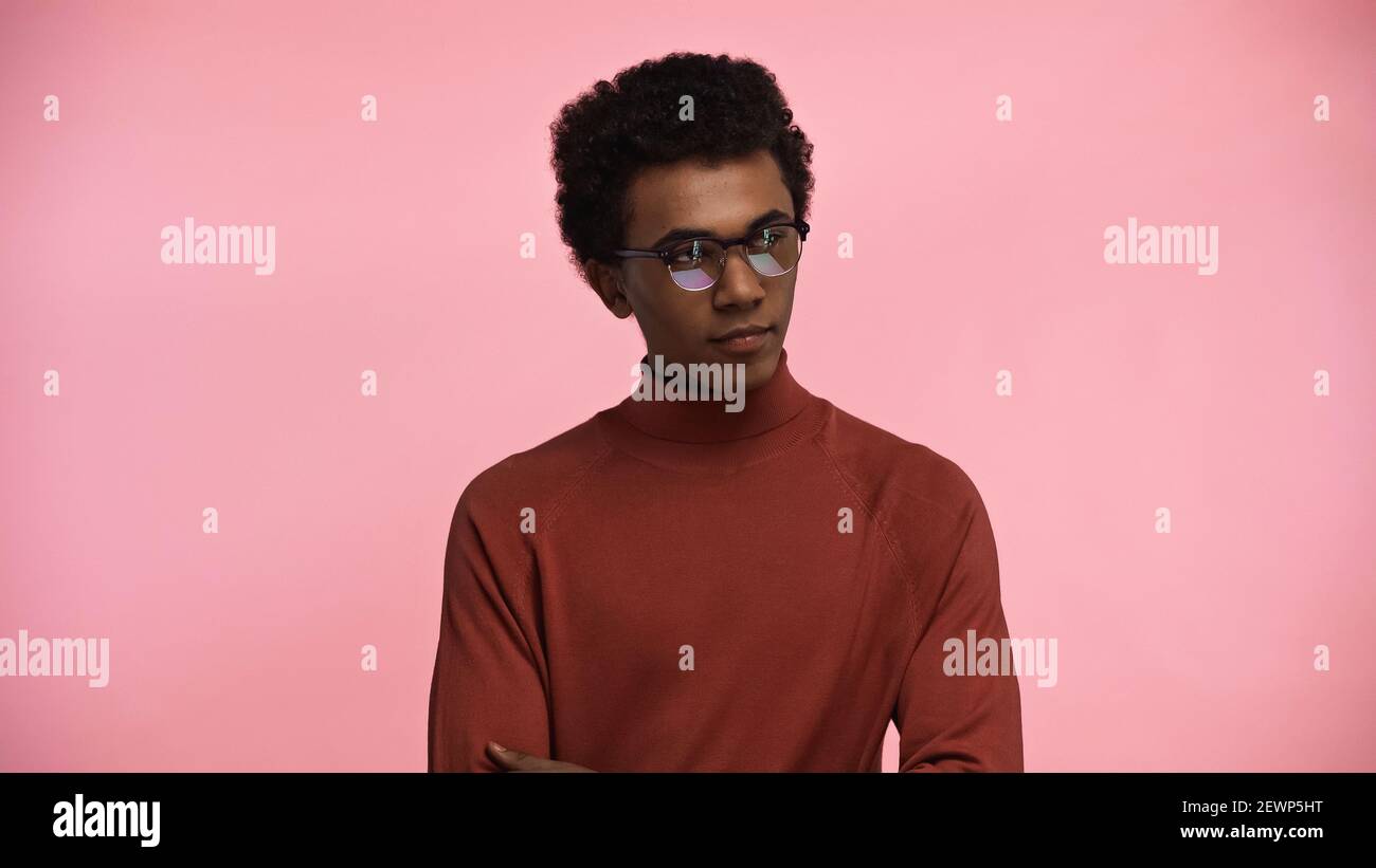 afroamerikanischer Teenager in Rollkragenpullover und Brille isoliert auf Rosa Stockfoto