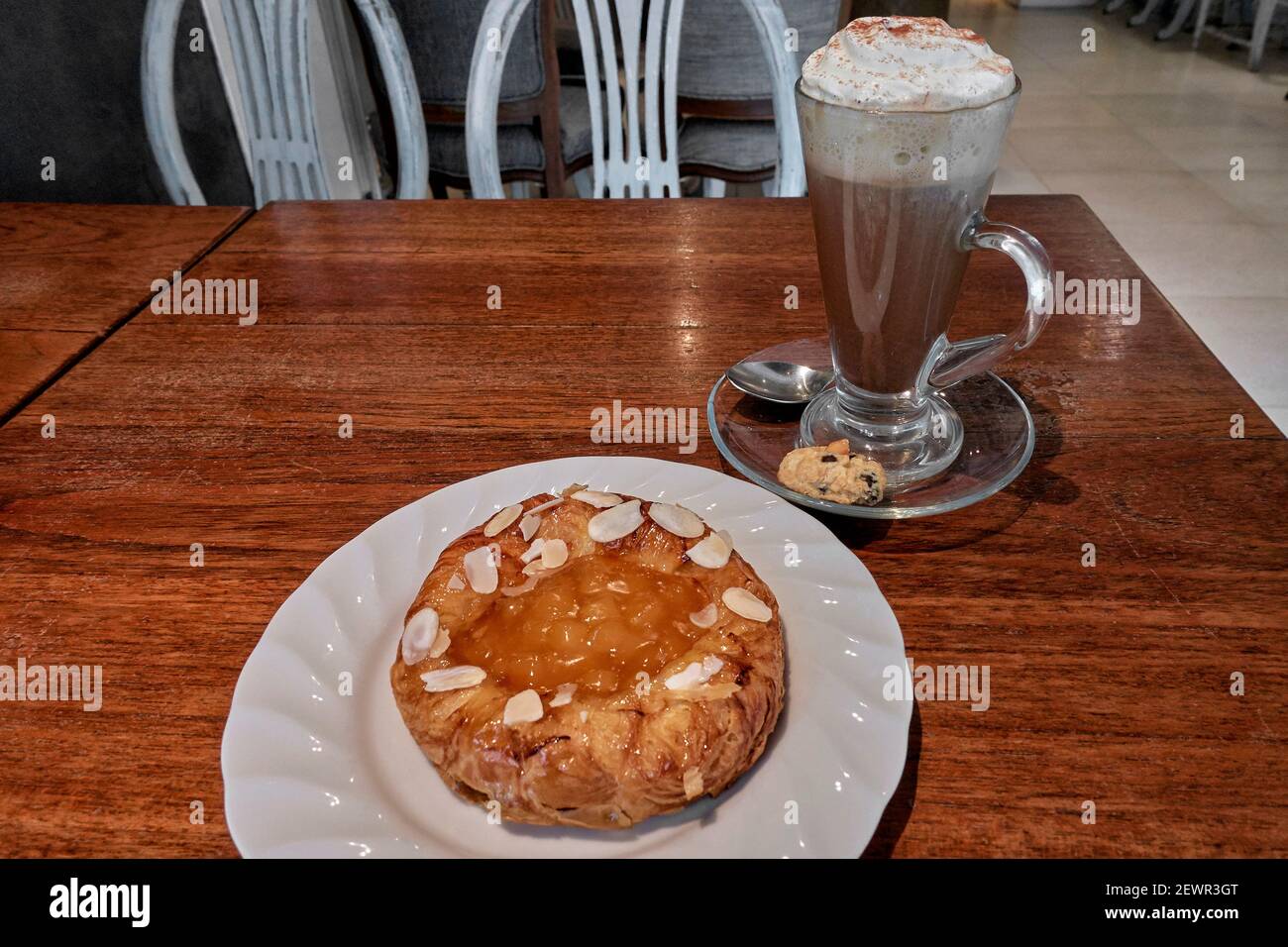 'Kaffee mit Kuchen'. Mokka-Kaffee mit Sahne-Belag und Aprikosengebäck mit Mandel-Belag. „Kaffee und Kuchen“ Stockfoto