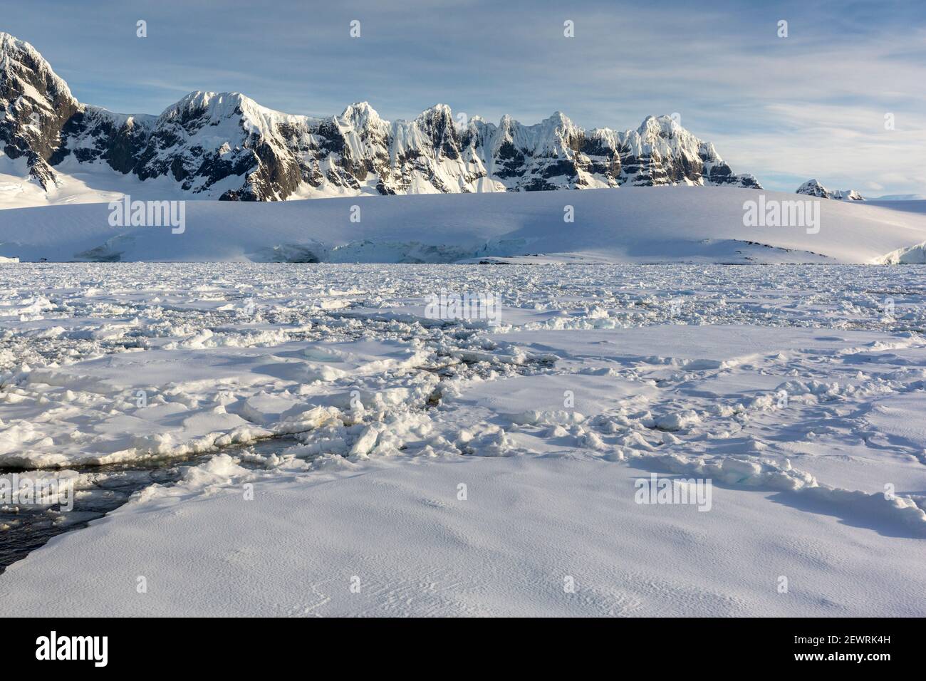 Schneebedeckte Berge und dichtes Meereis im Neumayer-Kanal, Palmer-Archipel, Antarktis, Polarregionen Stockfoto