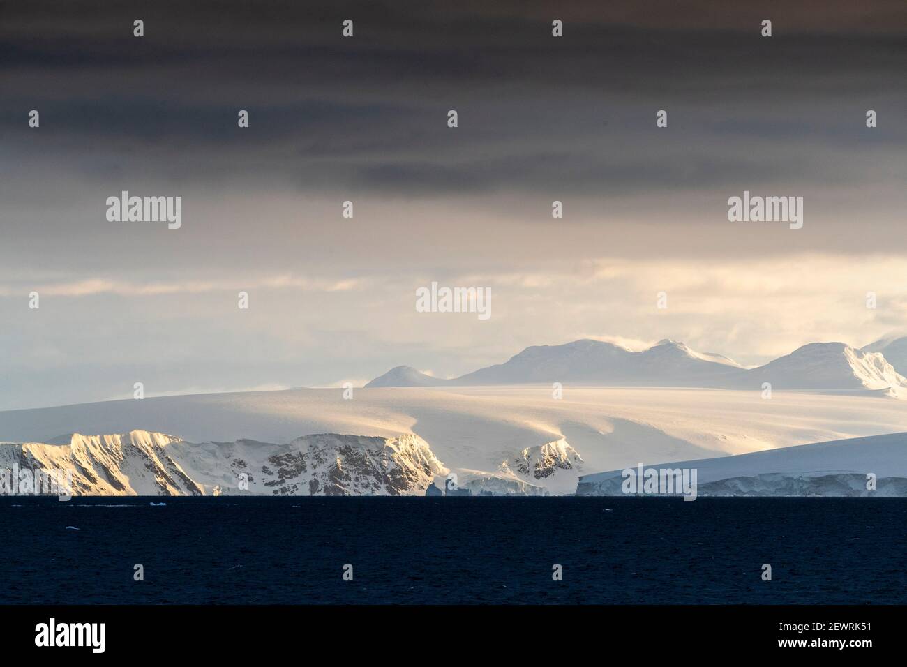 Sonnenaufgang auf schneebedeckten Bergen und Gezeitengletschern im Mikkelsen Harbour, Trinity Island, Antarktis, Polarregionen Stockfoto