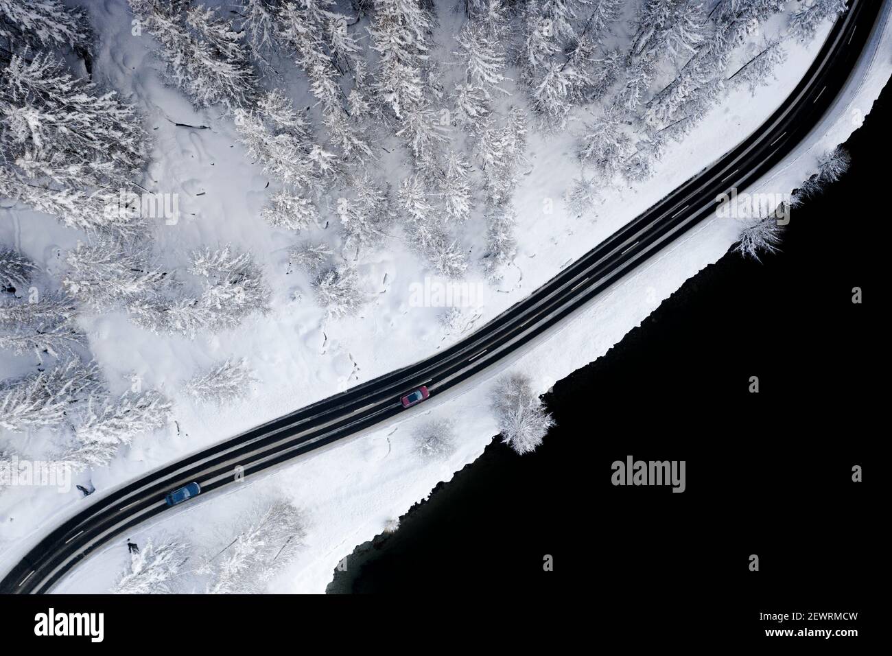 Autos fahren auf vereister Straße durch verschneite Wälder am Rande des Sils, Luftbild, Engadin, Graubünden Kanton, Schweiz, Europa Stockfoto