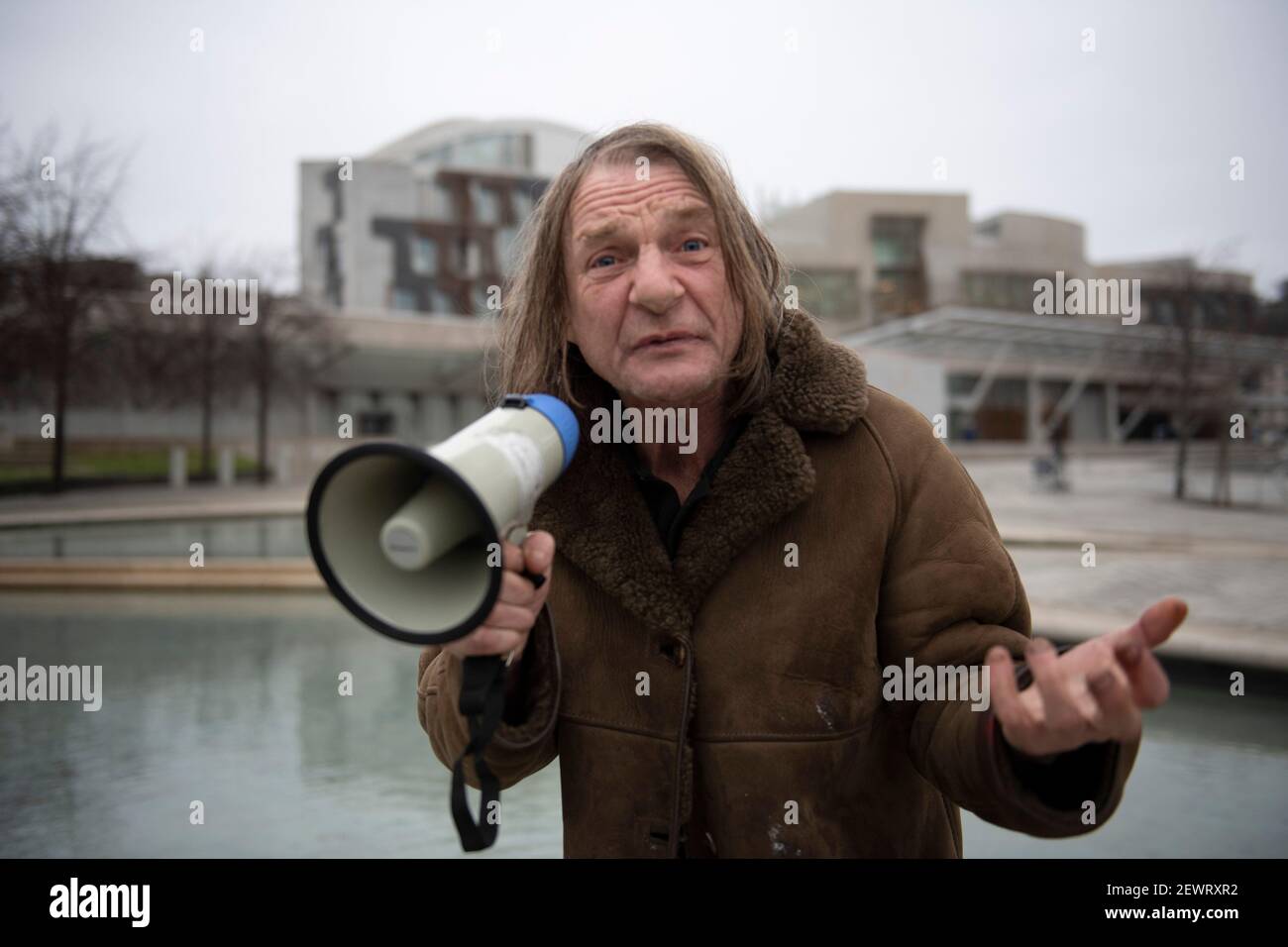 Edinburgh, Schottland, Großbritannien. März 2021, 3rd. Im Bild: Ein Protestor, der sich selbst nennt, schreit „King James“ durch sein tragbares Megaphon vor dem schottischen Parlament. Er sagt: „Schau dir den Zustand an, in dem sich unser Land befindet.“ Er hat eine tragbare boombox getoblaster, die er Karren herum auf einem Trolley Musik spielen. Quelle: Colin Fisher/Alamy Live News Stockfoto