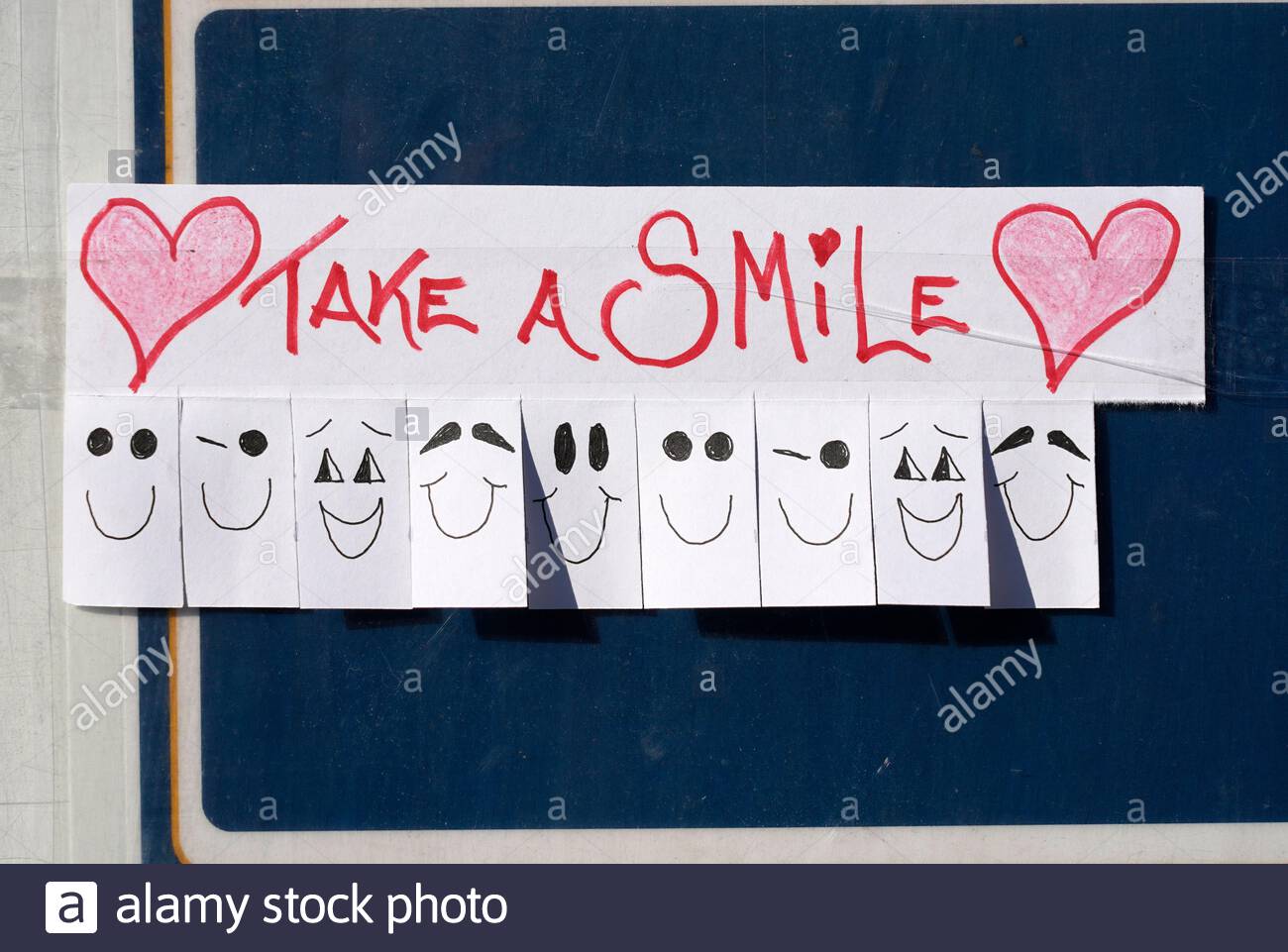 Take a Smile, freie Zeichnungen stecken auf einem Bustop Stockfoto