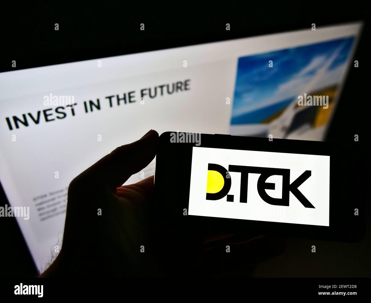 Person hält Smartphone mit Logo der ukrainischen Energieunternehmen DTEK auf dem Bildschirm vor der Website. Konzentrieren Sie sich auf die Telefonanzeige. Nicht modifiziertes Foto. Stockfoto