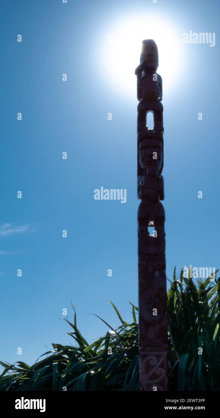 Traditionelles Maori-Totem aus Holz mit aufgehender Sonne und hellblauem Himmel, Portrait aufgenommen am Mount Victoria, Wellington, Neuseeland Stockfoto
