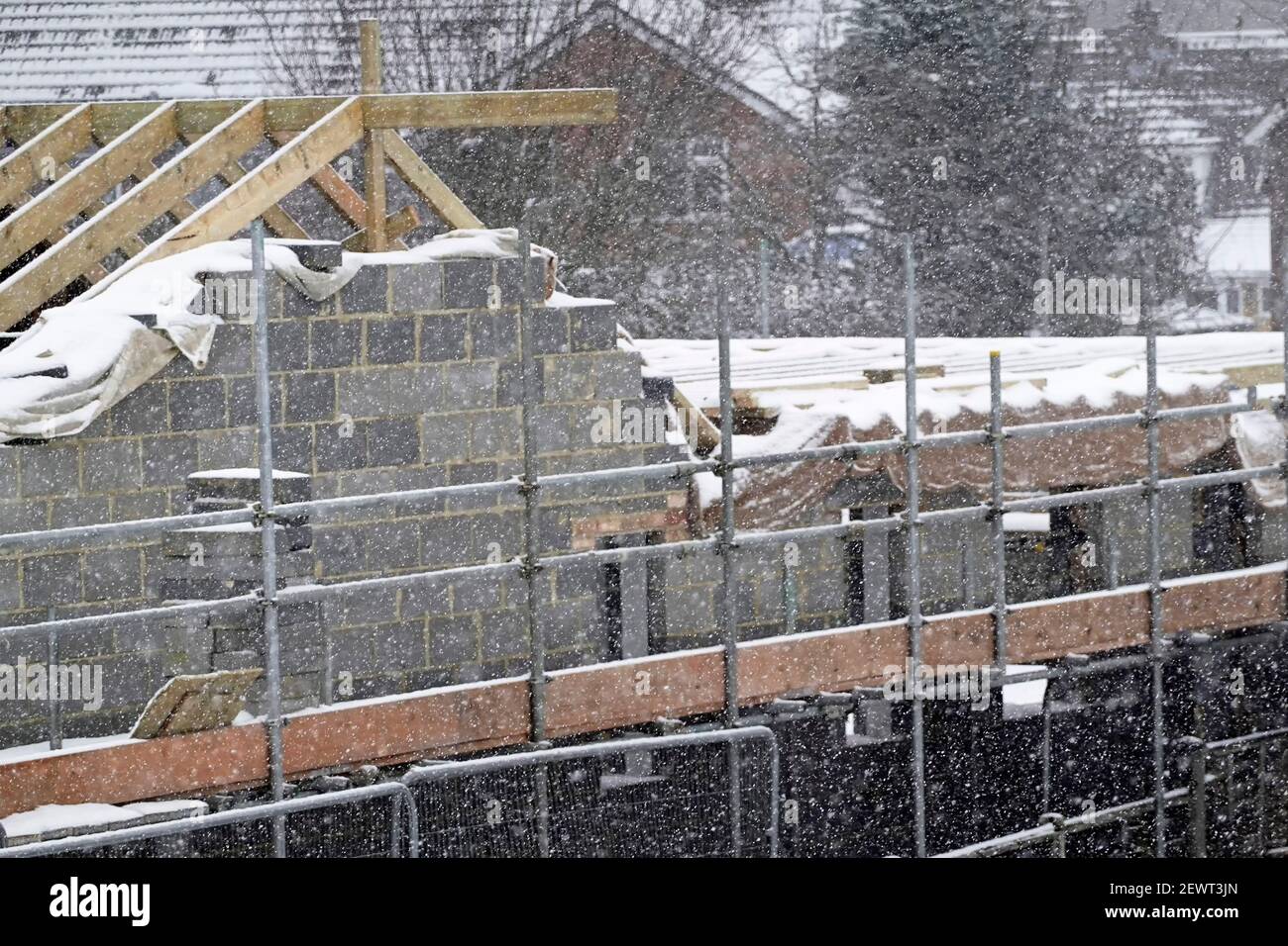 Die Arbeiten auf der Baustelle halten das Eis am Gerüstarbeitsplatz an Unsicher bei schlechtem, eisigen Winterschneesegfall, das Störungen verursacht England, Großbritannien Stockfoto