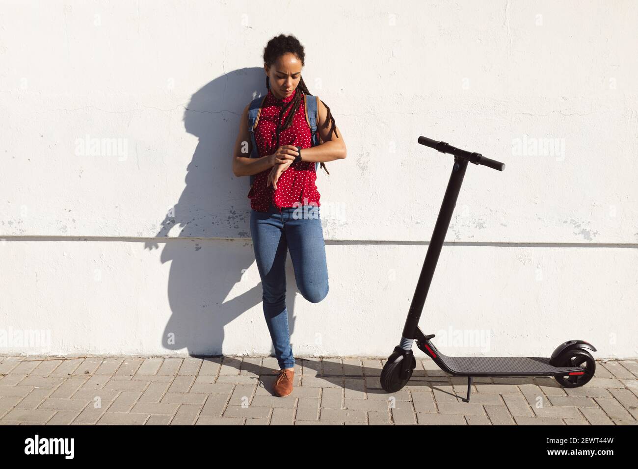 Afroamerikanische Frau runzelte die Stirn und überprüfte die Zeit auf dem Smartwatch-Roller neben ihr Stockfoto
