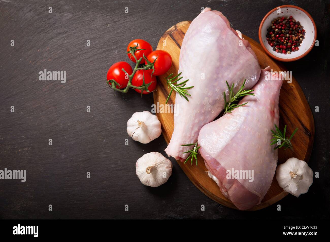 Frische putenbeine mit Zutaten zum Kochen auf dunklem Hintergrund, Draufsicht Stockfoto