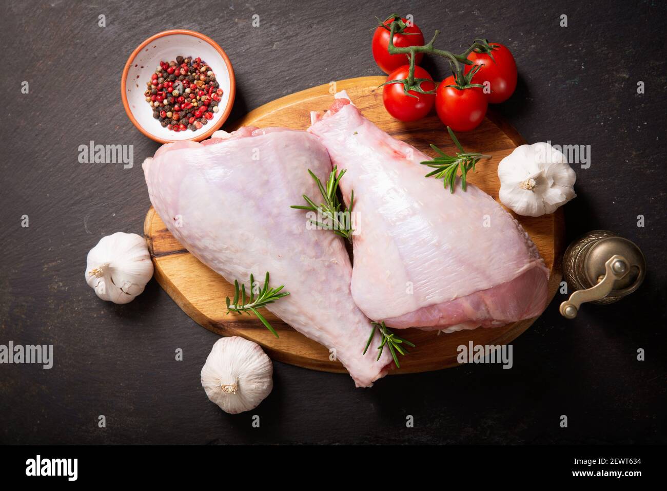 Frische putenbeine mit Zutaten zum Kochen auf dunklem Hintergrund, Draufsicht Stockfoto
