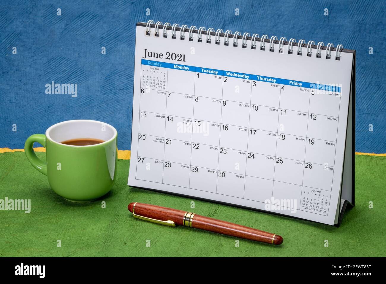 Juni 2021 - Spirale Desktop-Kalender gegen abstrakte Papierlandschaft mit einer Tasse Kaffee, Zeit und Geschäftskonzept Stockfoto