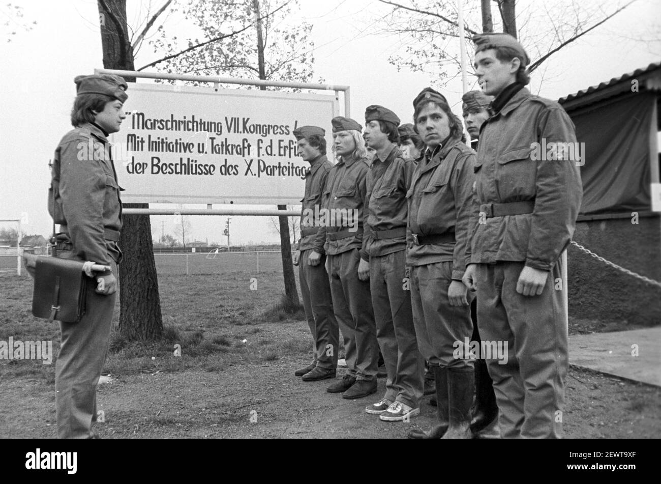 30. November 1981, Sachsen, Delitzsch: Teilnehmer. Unter der Schirmherrschaft des GST finden, wie hier 1982 in Delitzsch, Bezirksmilitärparaden statt. Im Hintergrund der Slogan: 'Marschrichtung VII. Kongress/mit Initiative und Tatkraft für die Erfüllung der Beschlüsse des X. Parteitages! Parteitag!“ Das genaue Datum des Fotos ist nicht bekannt. Foto: Volkmar Heinz/dpa-Zentralbild/ZB Stockfoto