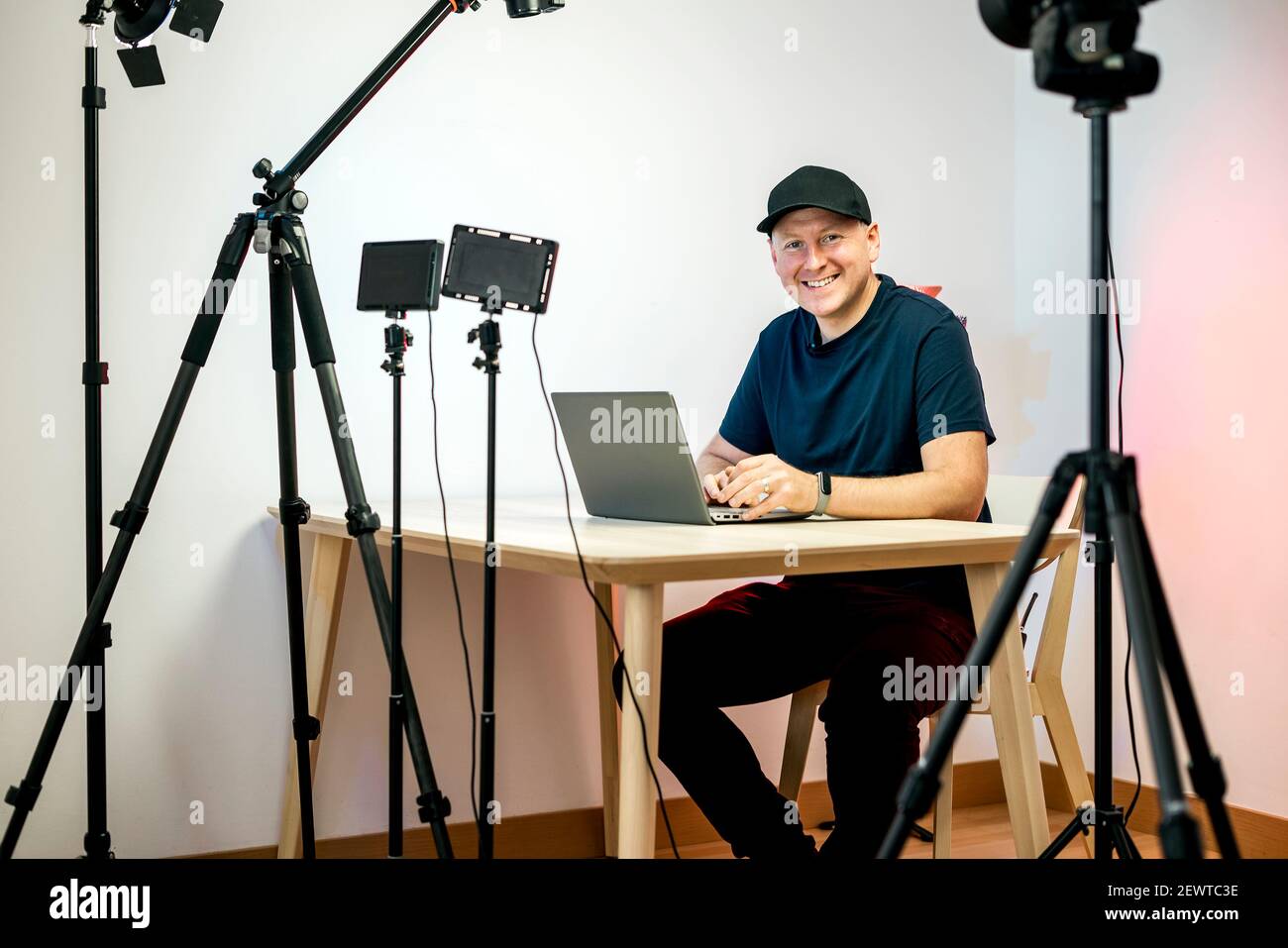 Ein Influencer mit einem Laptop, der Inhalte in erstellt und aufzeichnet Sein Studio Stockfoto