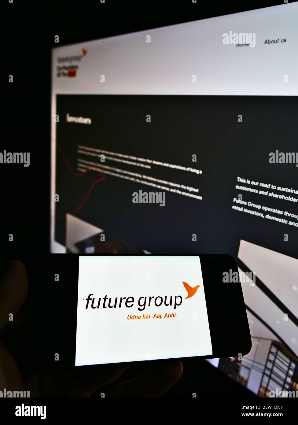 Person hält Handy mit Business-Logo des indischen Konglomerats Future Group auf dem Bildschirm vor der Firma Webseite. Konzentrieren Sie sich auf die Telefonanzeige. Stockfoto