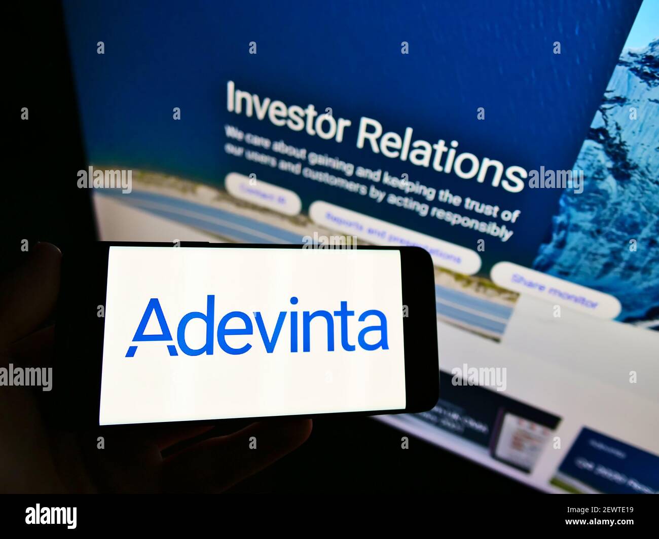Person, die Mobiltelefon mit dem Logo des norwegischen E-Commerce-Unternehmens Adecinta ASA auf dem Bildschirm vor der Business-Webseite hält. Konzentrieren Sie sich auf die Telefonanzeige. Stockfoto