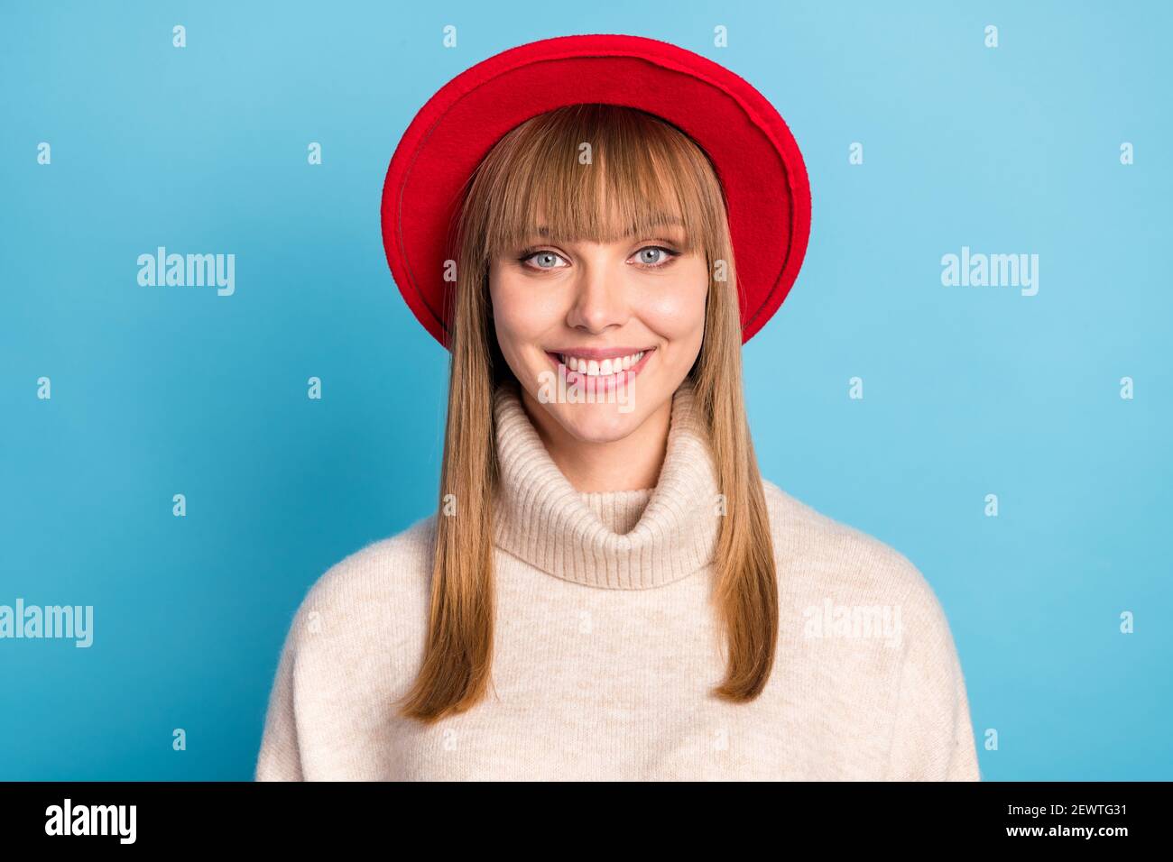 Portrait Foto Mädchen tragen beige Rollkragen roten Hut lächelnd glücklich Isolierter heller blauer Hintergrund Stockfoto