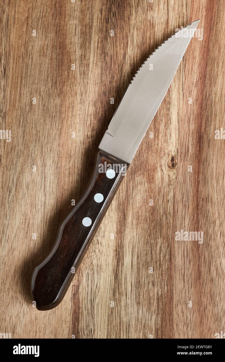 Küchenmesser für Steak und Fleisch auf Holzbrett, Nahaufnahme Stockfoto