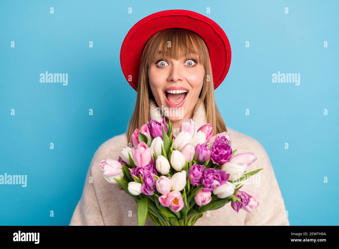 Portrait Foto Modell erstaunt halten Tulpen Bouquet im Frühjahr isoliert Lebendiger blauer Hintergrund Stockfoto