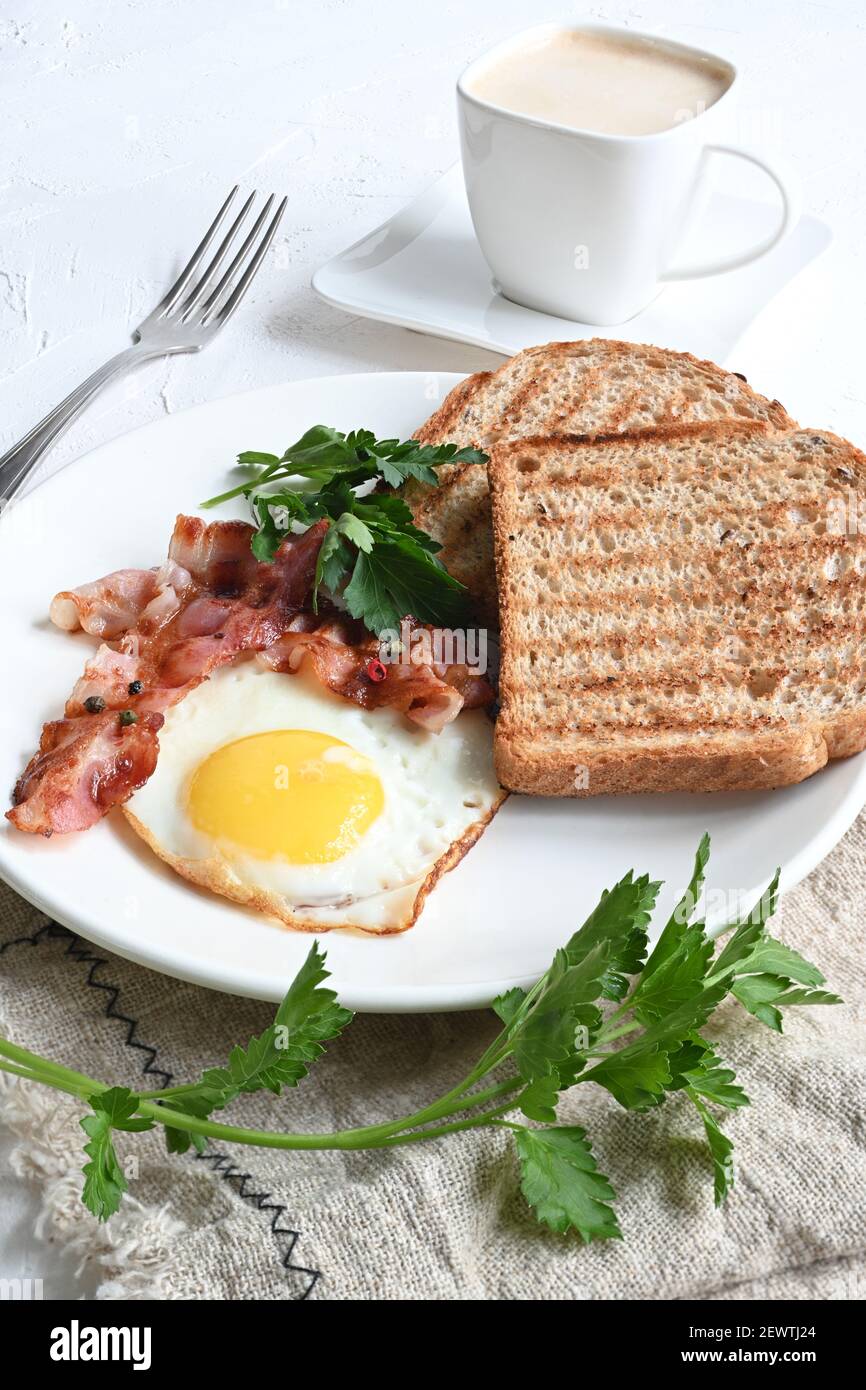 Frühstück mit Spiegeleiern, Toast und Kaffee auf weißem Hintergrund. Stockfoto