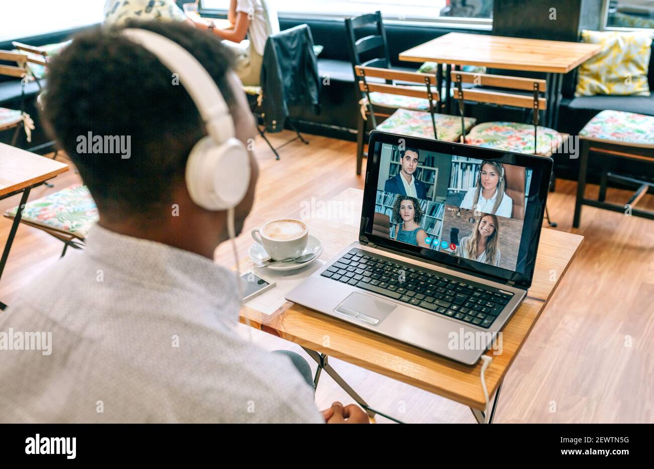 Mann, der durch Videokonferenz aus einem Café arbeitet Stockfoto