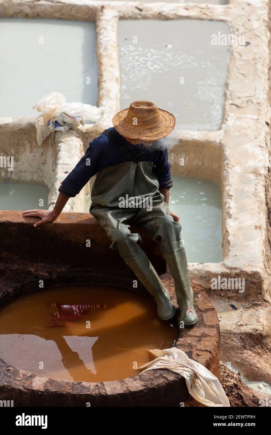 Ein Einheimischer rast neben den honiggekämmten Erdgruben in Chouara Tannery, Fes, Marokko Stockfoto