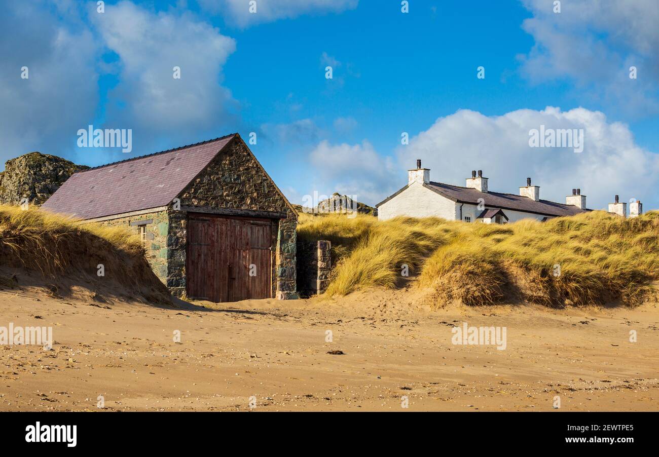 Das Lifeboat Haus und die Dächer der weißen Pilot's Cottages vom Strand auf Llanddwyn Island, Anglesey, Wales Stockfoto