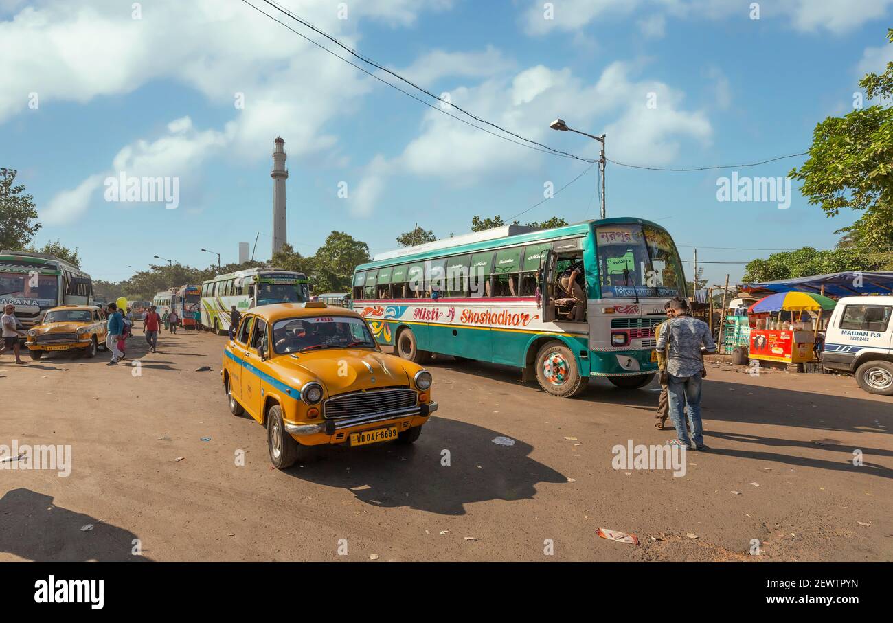 Gelbes Taxi mit öffentlichen Verkehrsmitteln Busse am Busbahnhof Mit Blick auf das historische Shaheed Minar in Kalkutta Indien Stockfoto