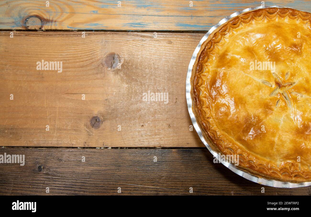 Eine köstliche Fleisch Pie Top Down Ansicht zeigt die leckere Fleischpastete und Kruste auf einem hölzernen Küchentisch Stockfoto