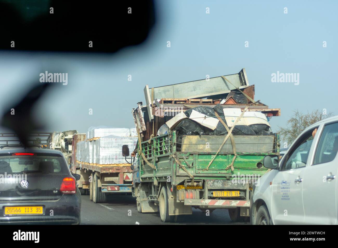 Rückansicht eines kleinen LKWs, der den Schrott hereinträgt Der Verkehr auf der Autobahn Stockfoto