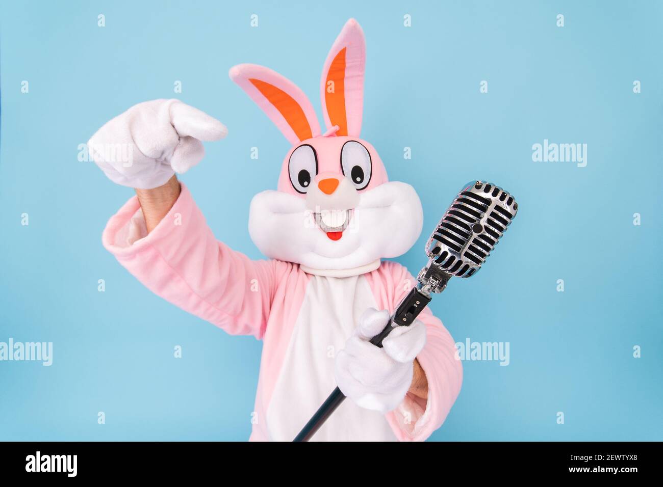 Glücklich lustige Kind Junge oder Mädchen Sänger oder Sänger singt Lied Retro Vintage klassischen Mikrofon. Osterhase oder Kaninchen oder Hase feiert Frohe ostern Stockfoto