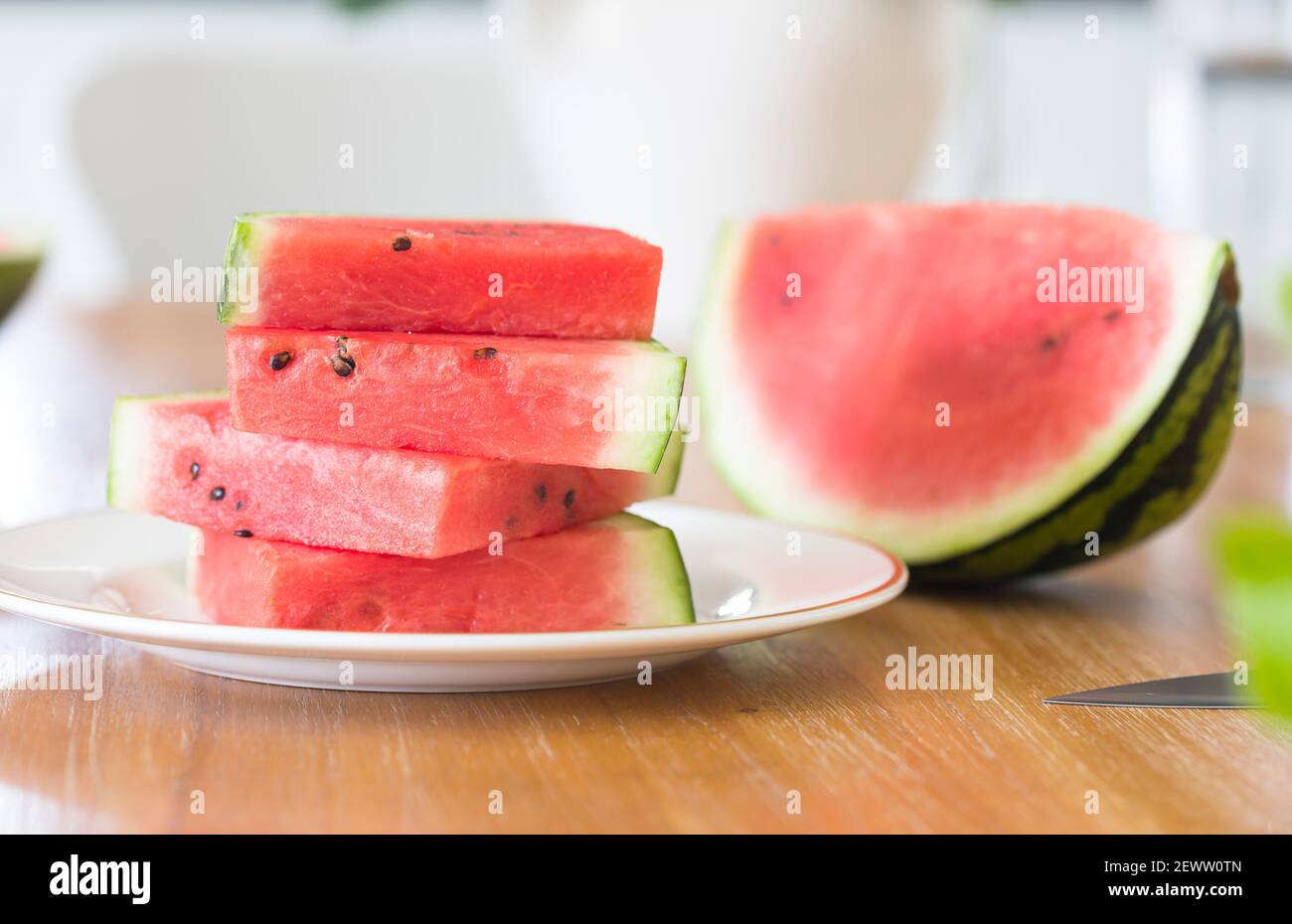 Reife geschnittene Scheiben Wassermelone auf einem Teller, geschnittene Wassermelonen auf einem Tisch in einer britischen Küche oder einem Esszimmer Stockfoto