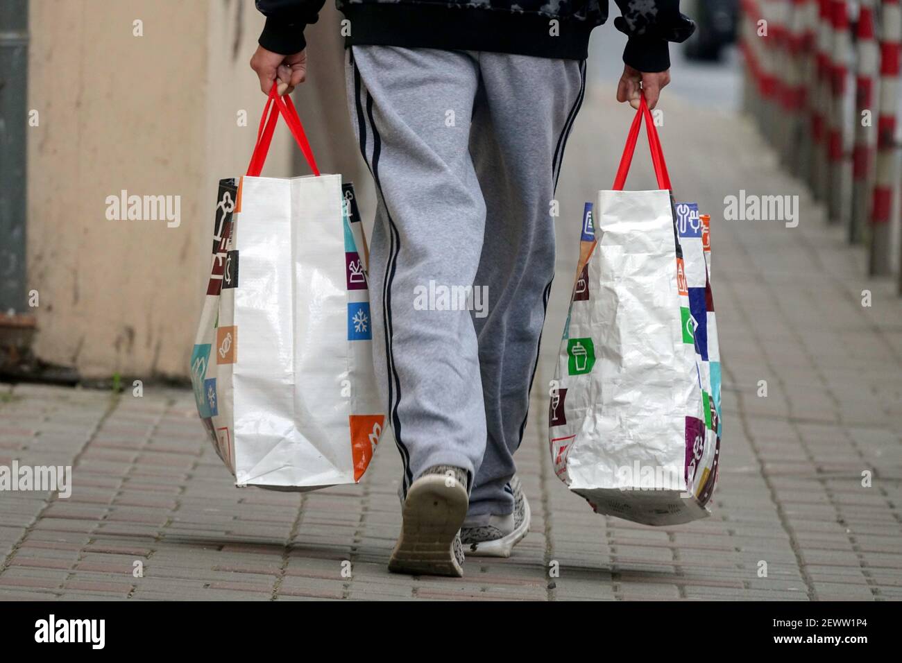 Der Mann trägt zwei Supermarkttaschen, der Mann geht weg Stockfoto