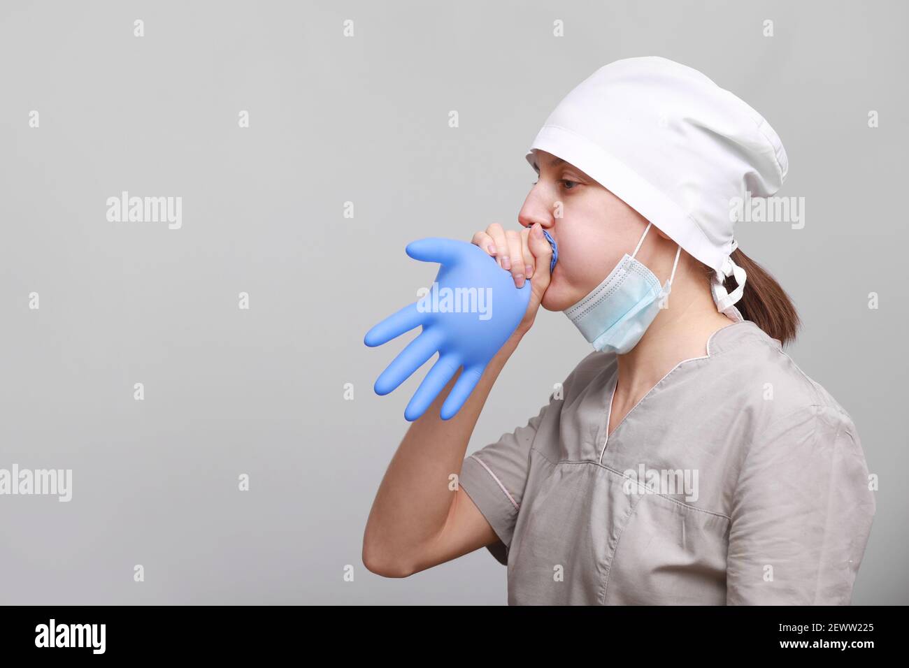 Lustig lchelnd weibliche Krankenschwester oder Arzt in medizinischen  Uniform und Schutzmaske aufblht blauen Latex-Handschuh auf weiem  Hintergrund isoliert Stockfotografie - Alamy