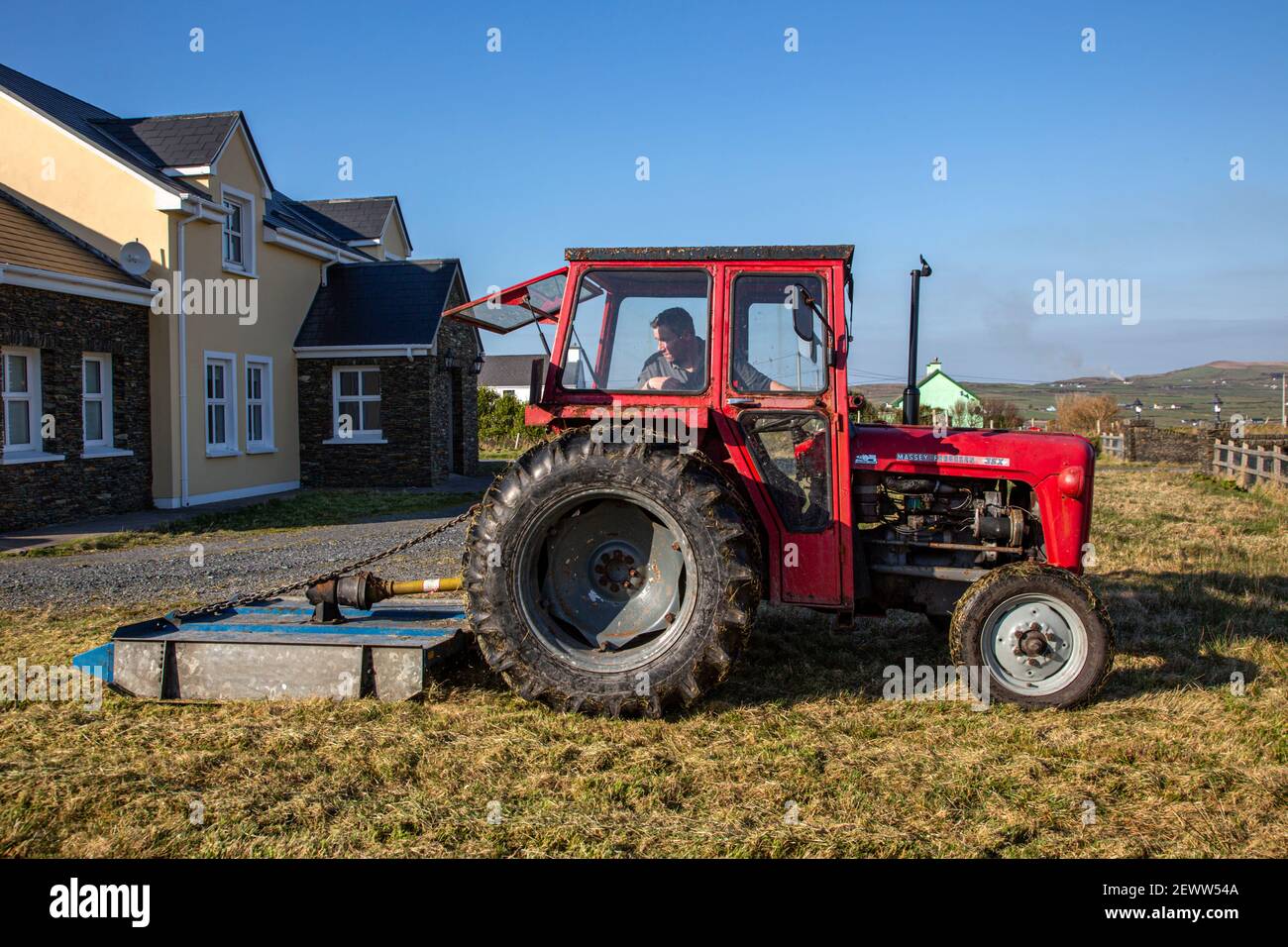 Kleiner Grasschlepper, der von einem Traktor gezogen wird Inlandsland Stockfoto
