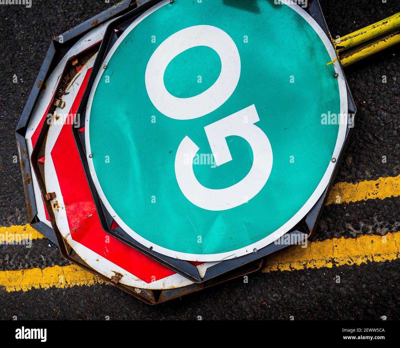 Straßenarbeiten Stop Go Schilder auf einer Straße bereit für den Einsatz. Tragbare Straßenbauschilder. Straßenverkehrskontrollschilder - Green Go-Schild. Stockfoto