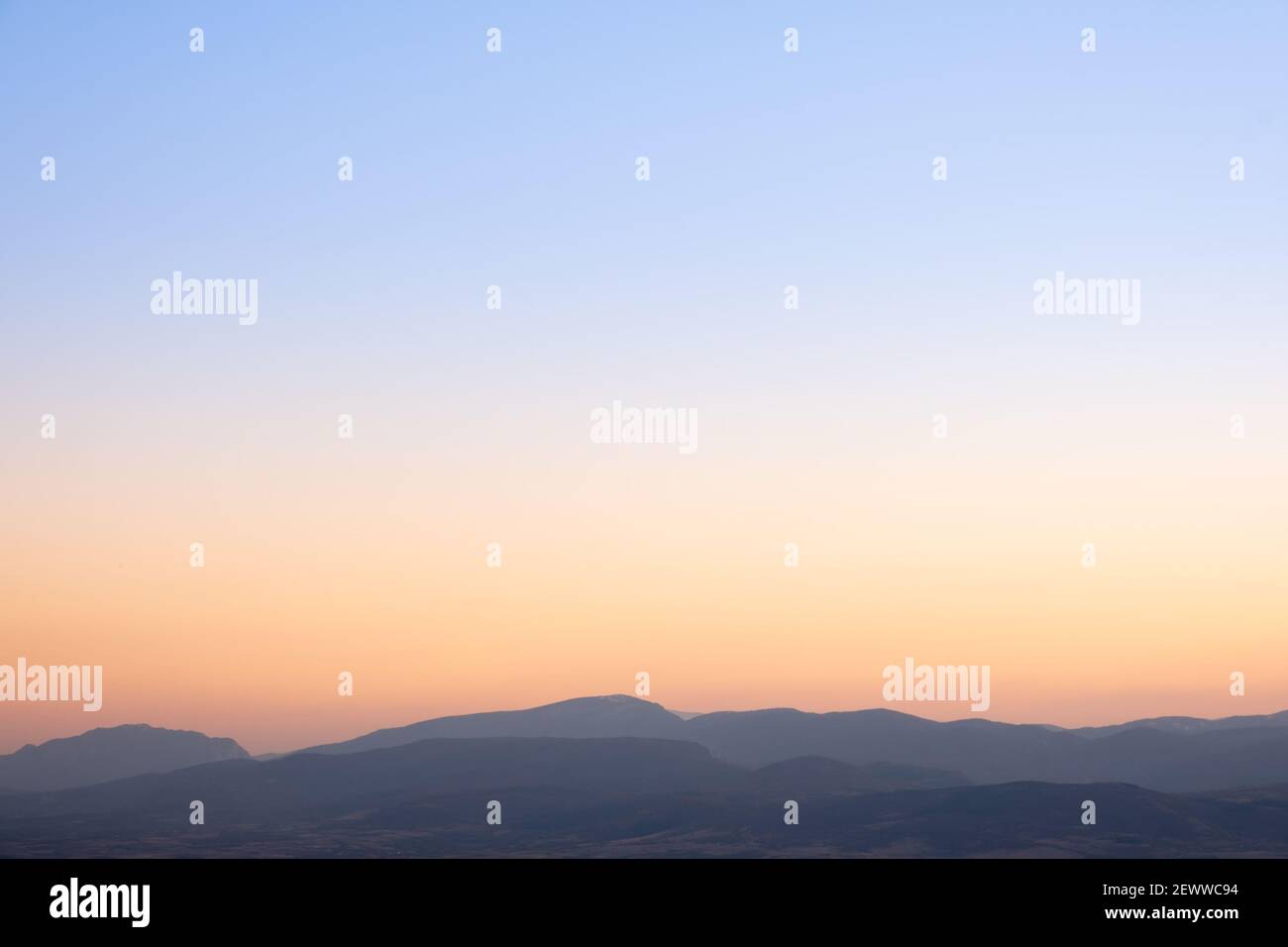 Schöner Sonnenuntergang Himmel, blau an der Spitze und golden orange über den Shilouette Horizont Berge Stockfoto