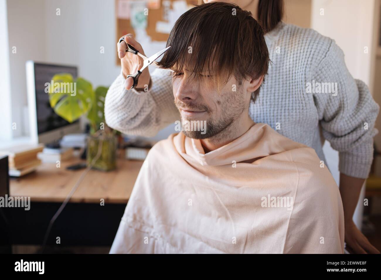 Haarschnitt zu Hause. Mann, der zu Hause Haare schneidet. Leben in einer Pandemie während der Sperrung. So schneiden Sie Ihr eigenes Haar, wenn Friseure geschlossen sind. Einfachste Selbsthaarschnitt Stockfoto