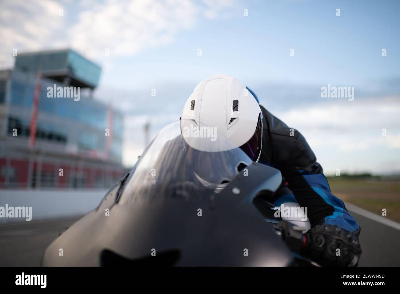 Unerkennbarer Mann, der auf der Strecke schnell Motorrad fährt Stockfoto