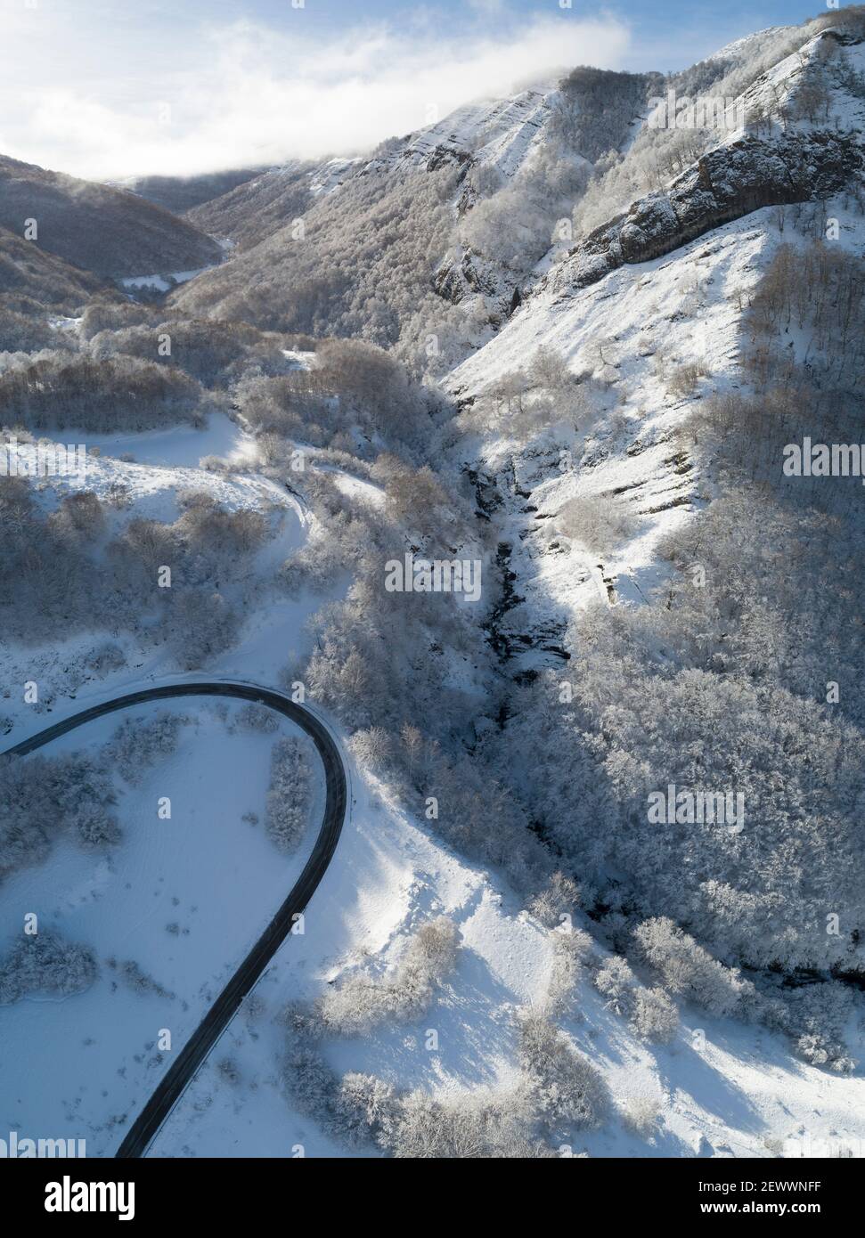 Hohe Bergkurve in verschneite Umgebung aus Drohnenansicht Stockfoto
