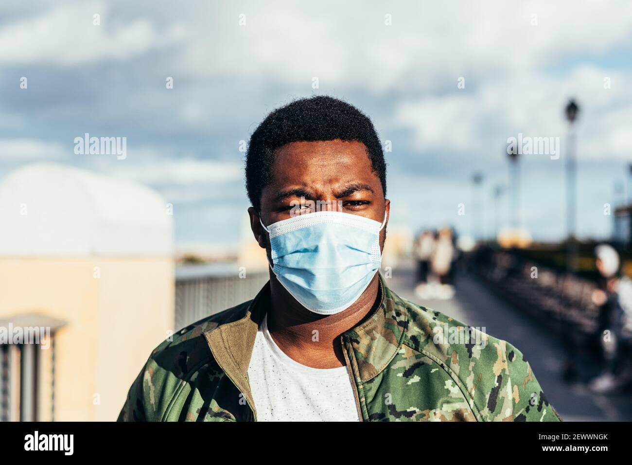 Porträt eines schwarzen Jungen mit Gesichtsmaske. In Militärjacke gekleidet. Stockfoto