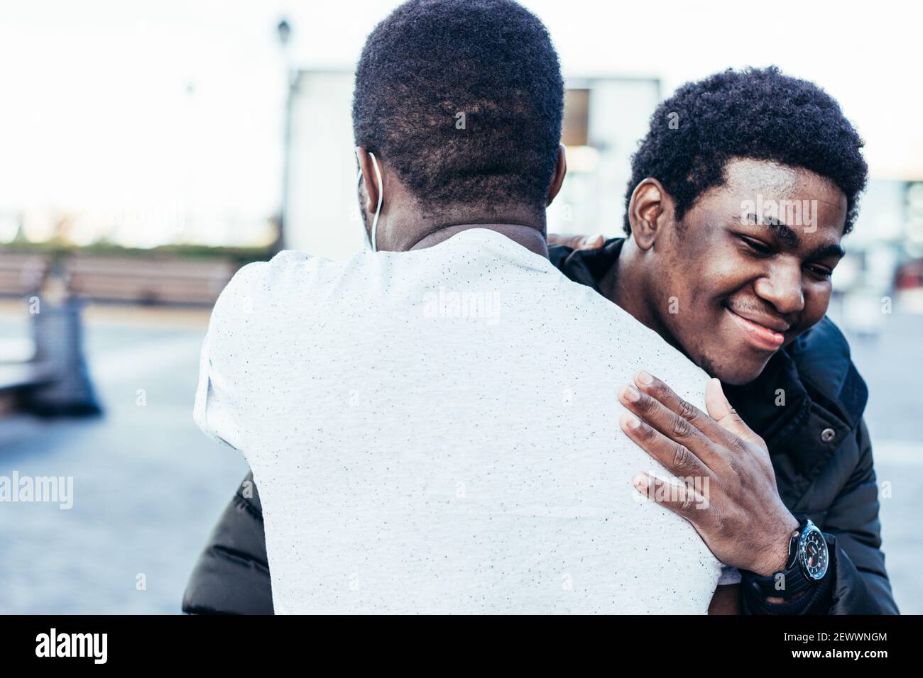 Porträt von zwei afroamerikanischen Freunden umarmen. Wiederbegegnung im urbanen Raum. Stockfoto