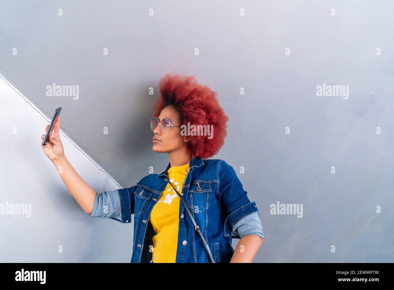 Frau mit roten Afro-Haaren, die ein Foto gemacht hat Stockfoto